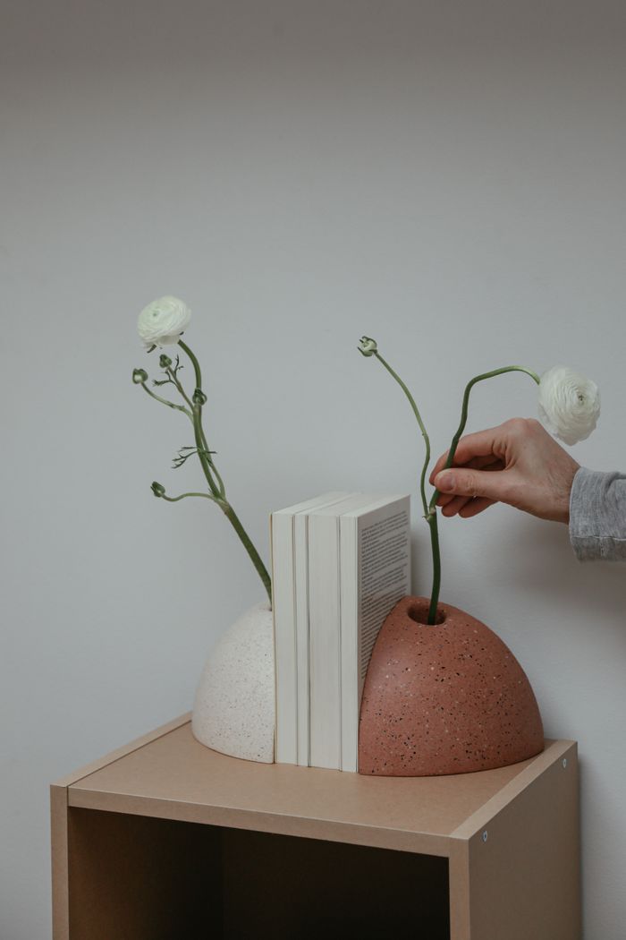 Elegant composition of vases with white flowers and books in a modern, minimalist style.